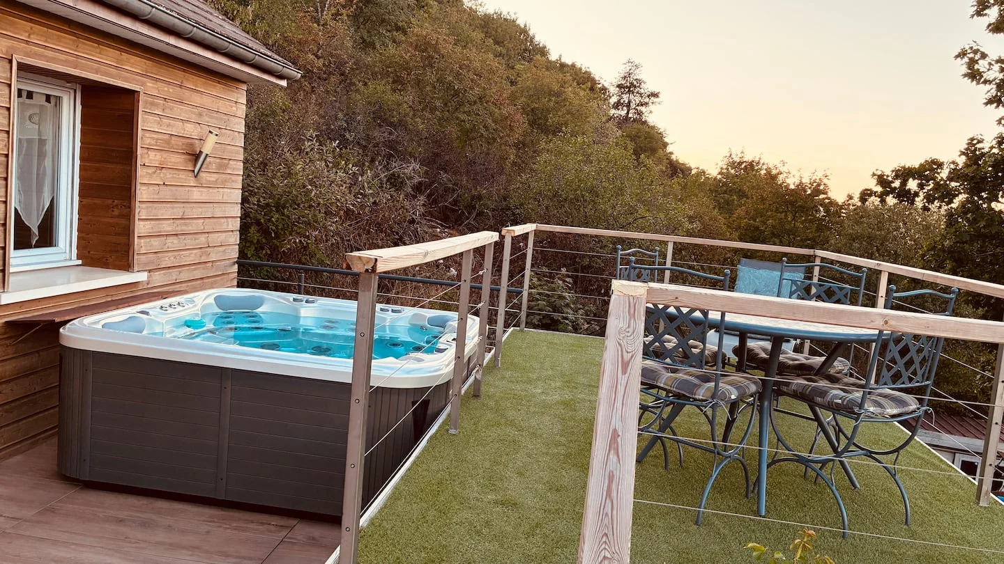 Le spa privé et la terrasse ouverts sur les collines verdoyantes de Dijon